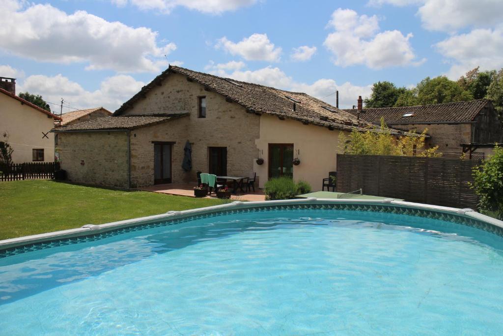 a large swimming pool in front of a house at Les Cerisiers Gîtes in Lezay