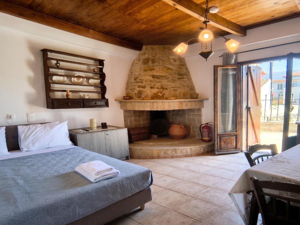 a bedroom with a bed and a fireplace at Sofia Apartments- Melidoni in Melidhónion