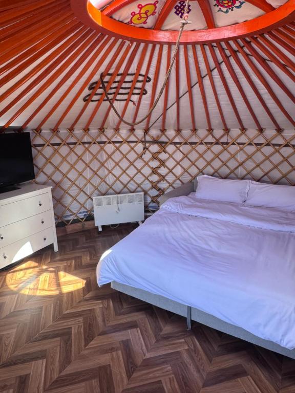 a bedroom with a bed and a tv in a yurt at Mongolian traditional house Ger in Dzuunmod