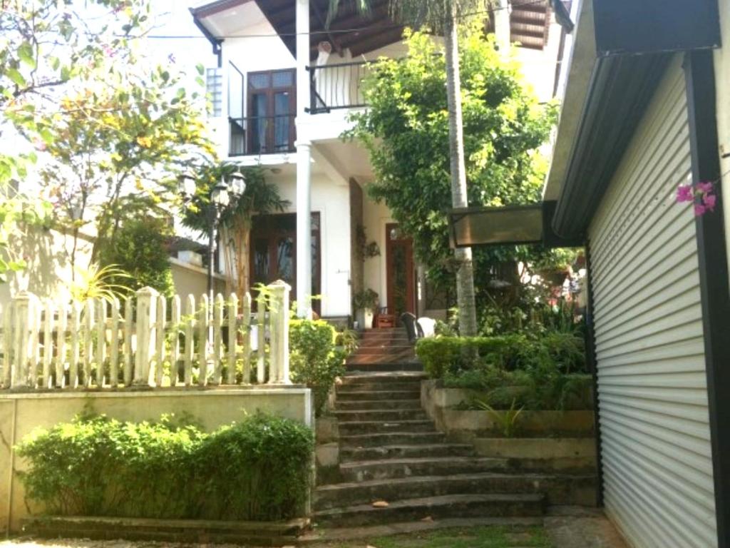 a stairway leading up to a white house at The Mulberry Villa kandy in Kandy