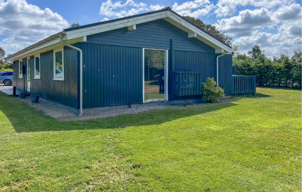 a blue house with a person standing in the doorway at 3 Bedroom Nice Home In Hals in Hals