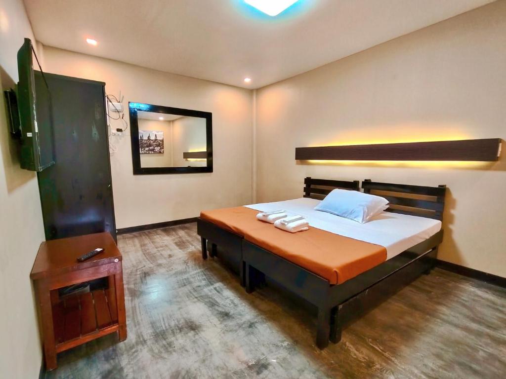 a bedroom with a large bed and a mirror at Pina Colina Resort Tagaytay City by RedDoorz in Tagaytay