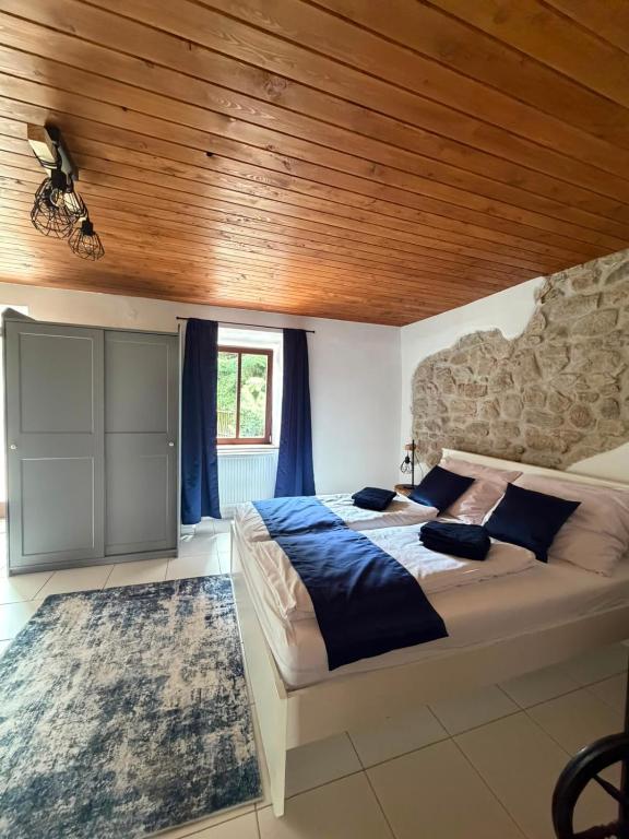 a bedroom with a large bed and a wooden ceiling at Mlýn Slavonice in Slavonice