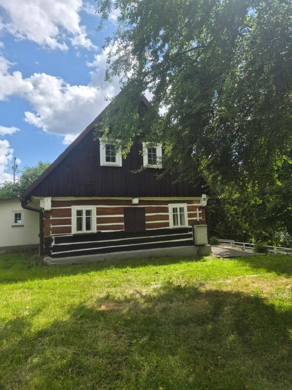 a large wooden house with a gambrel roof at Roubenka Krkonoše - Adršpach in Radvanice
