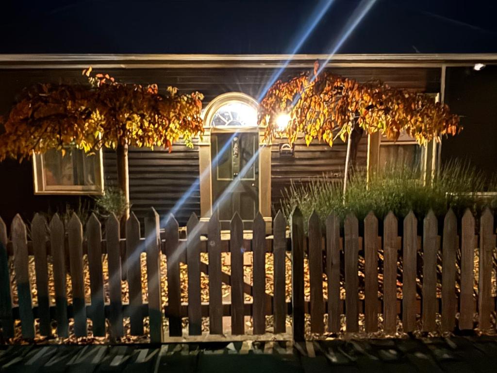 a fence in front of a house at night at Robinson Cottage in Oatlands