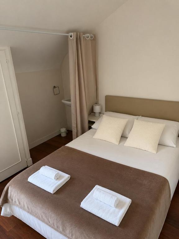 a bedroom with a large bed with two towels on it at La Canopée in La Gouesnière