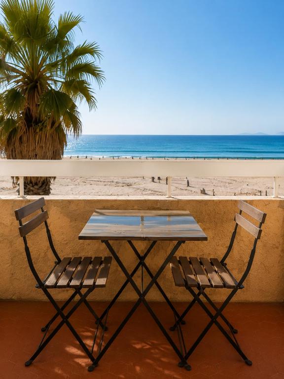 a picnic table and two chairs on the beach at ROSEVA - T2 Vue mer - Plage à pied - Balcon - Climatisation in Canet-en-Roussillon
