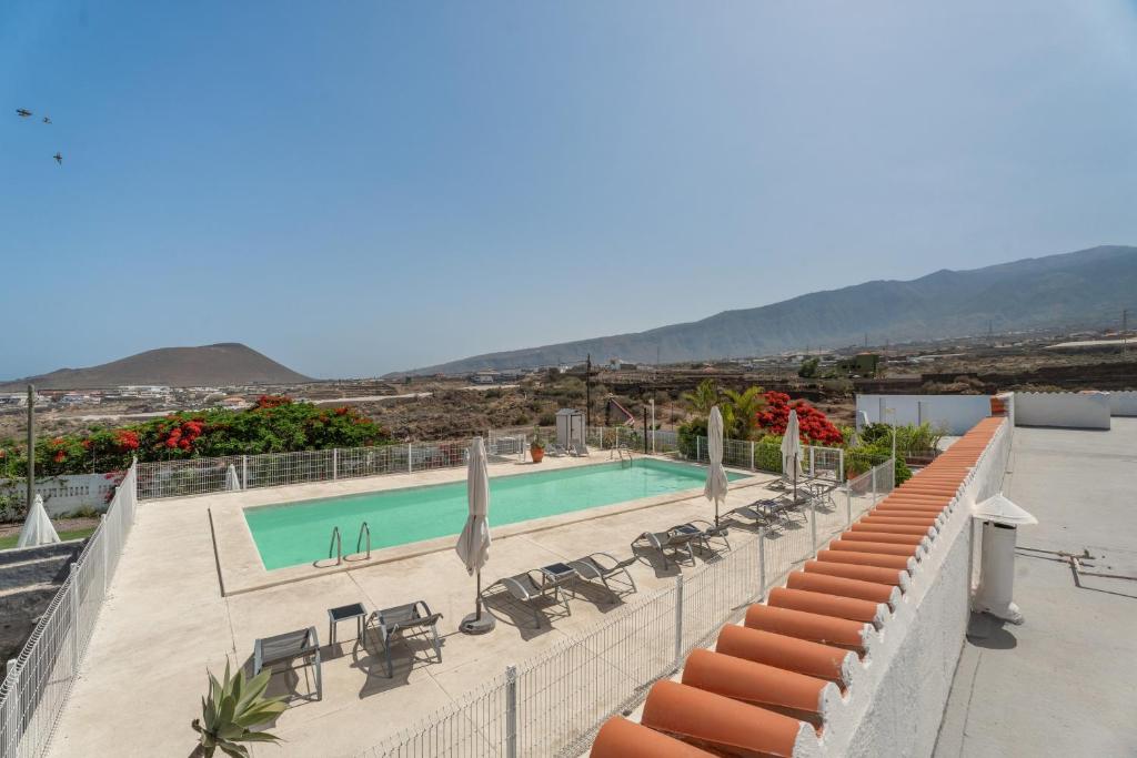 a swimming pool with tables and chairs and a view of mountains at Finca La Pampa in Arafo