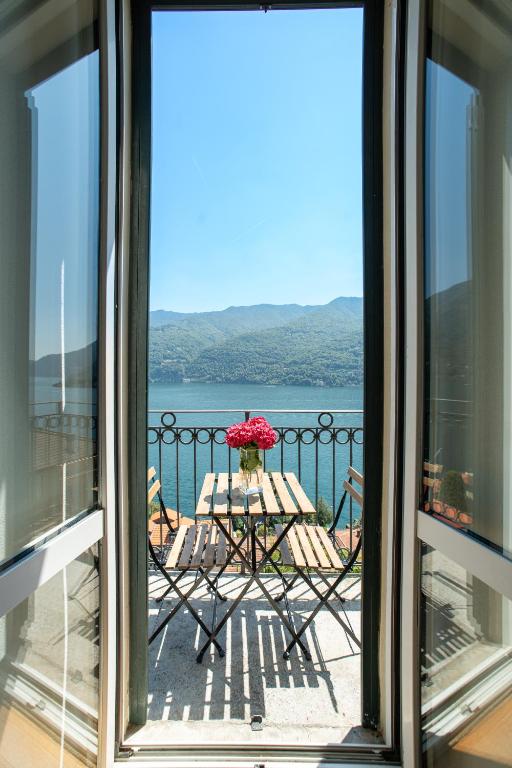a balcony with a table and a view of the water at Emy House Charming Apt Stunning Views Balcony AC in Carate Urio