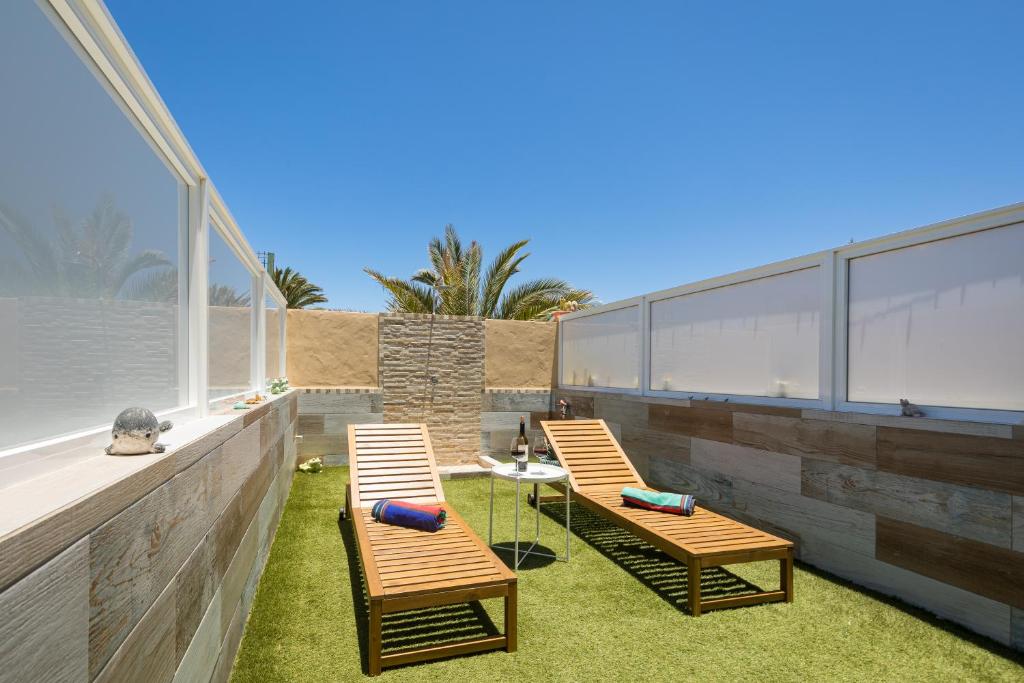 a patio with two chairs and a table on the grass at CarpeDiem Costa de Antigua in Costa de Antigua