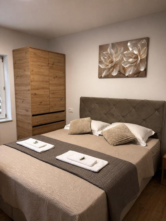 a bedroom with a large bed with two towels on it at Apartmani Đurišić in Posušje