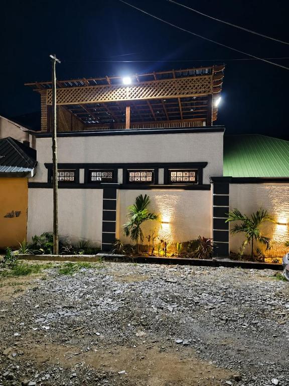 a building with palm trees in front of it at night at the urban escape in Kwabenyan