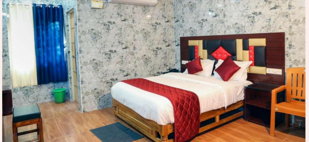 a bedroom with a large bed with red pillows at Anbu Grand Inn in Chidambaram