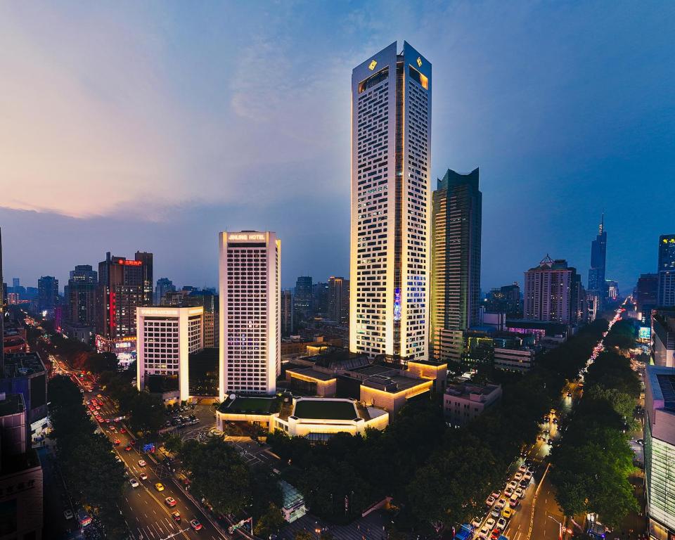 a city skyline with a tall skyscraper at Jinling Hotel in Nanjing