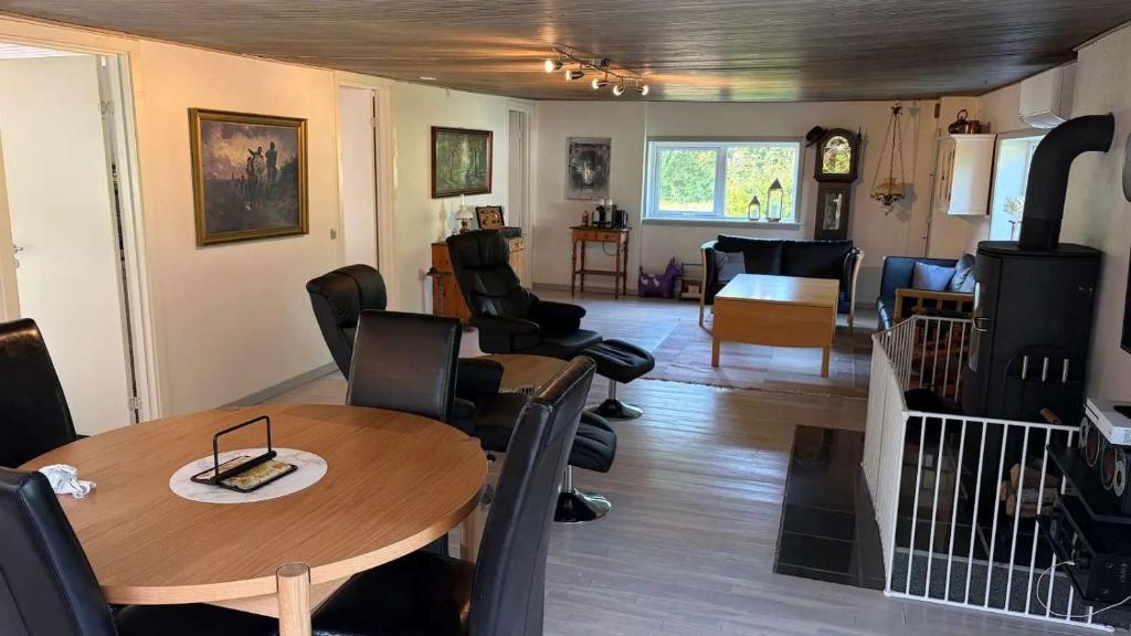 a dining room and living room with a table and chairs at Cozy Summerhouse in Vestervig