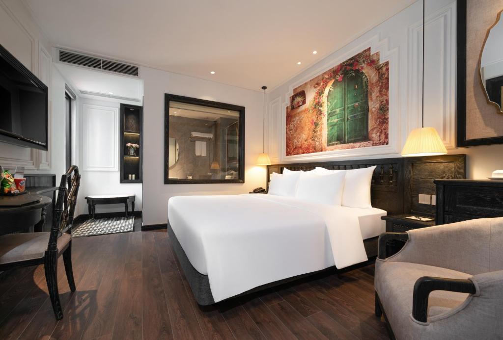 a white bedroom with a large white bed and a desk at LP Hotel & Spa Pham Hong Thai in Hanoi
