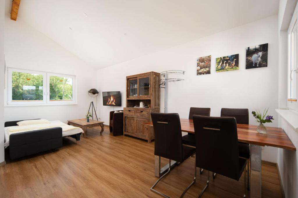 a living room with a dining room table and chairs at Chalets im Landhotel Pferdeschulze in Hitzacker