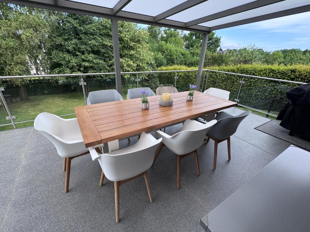 a wooden table and chairs on a patio at Haus Orion in Eupen