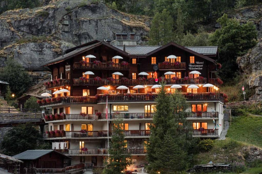 ein großes Gebäude mit vielen Balkonen auf einem Berg in der Unterkunft Hotel Edelweiss in Blatten im Lötschental