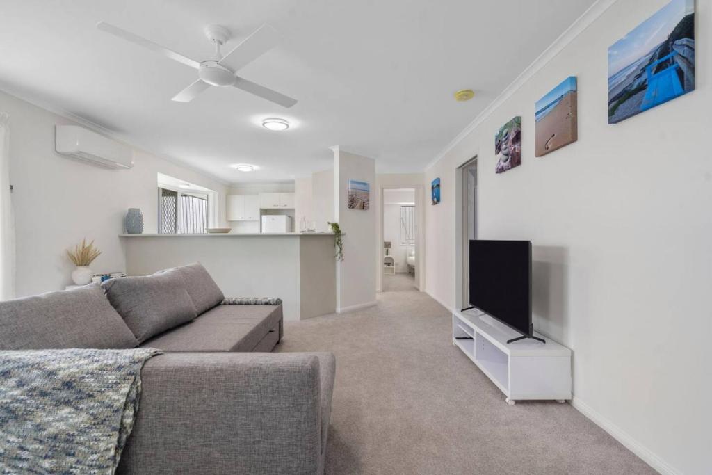 a living room with a couch and a flat screen tv at Cozy 2BR villa in Maroochydore in Maroochydore