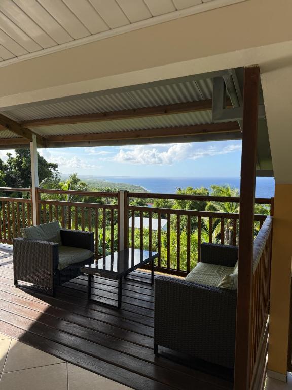 a balcony with chairs and a view of the ocean at Villa Bigaradier - Meublé 3 étoiles avec vue mer sur la côte Est in Sainte-Rose