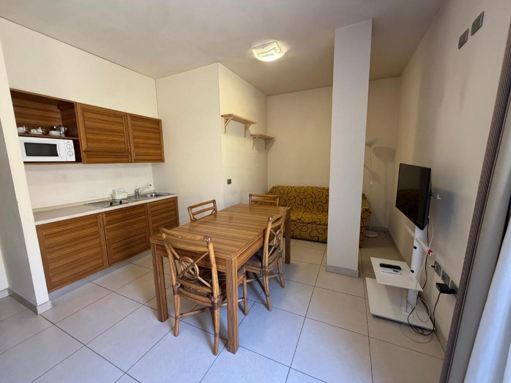 a kitchen and living room with a wooden table and chairs at Residenza La Signora vista mare con ascensore in Marotta