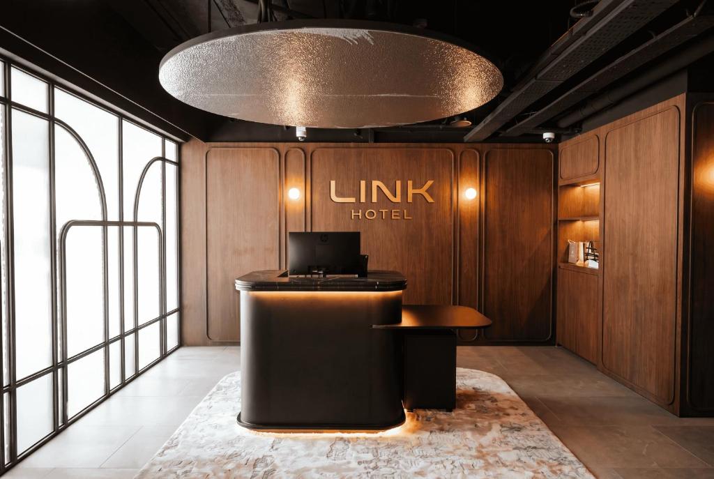 a lobby of a hotel with a desk and a sign at Link Hotel Singapore in Singapore