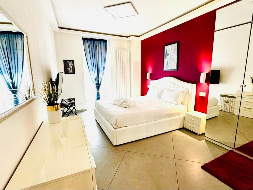a bedroom with a white bed and a red wall at Nice apartment in the historic center in Verbania