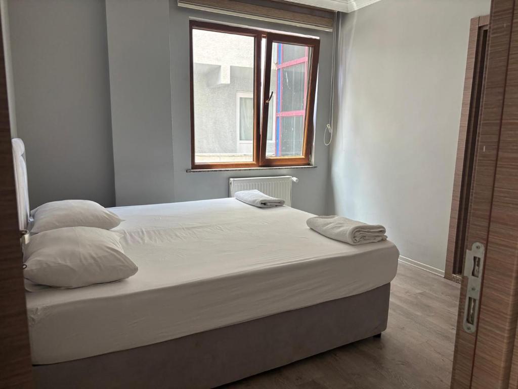 a bed in a room with a window at SİMGE Apt in Trabzon