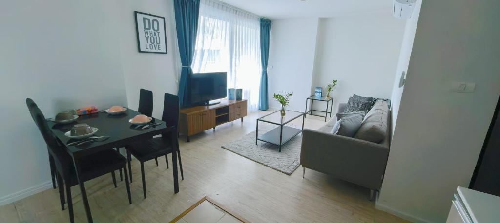a living room with a table and a couch at Centrio 2 bed rooms 52 in Ban Lo Long