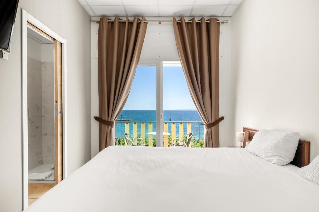 a bedroom with a large bed and a view of the ocean at Le Beau Séjour in Saint-Raphaël