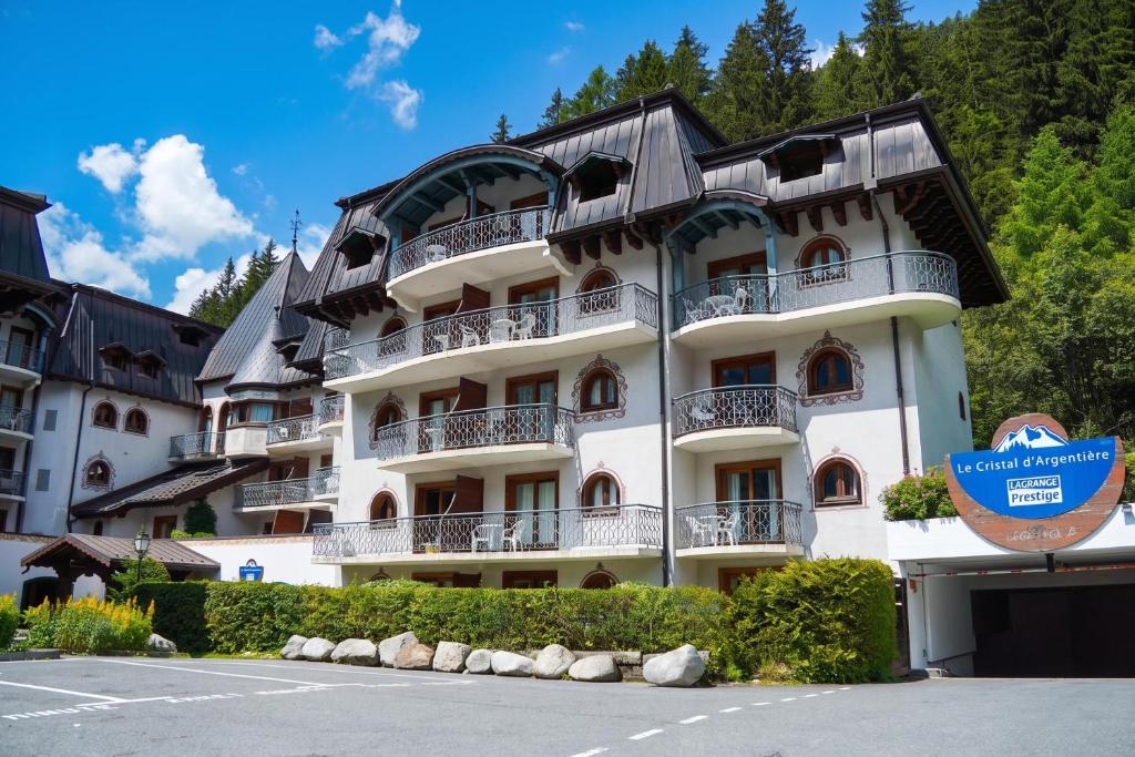 a large white building with a black roof at Résidence Le Cristal Apartments in Chamonix