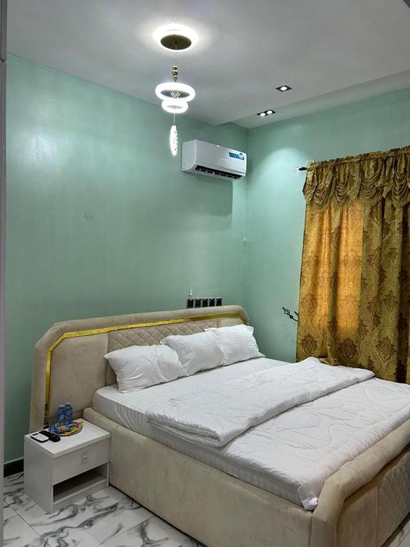 a bed in a room with a green wall at ACCENT HOMES Apartment in Asaba