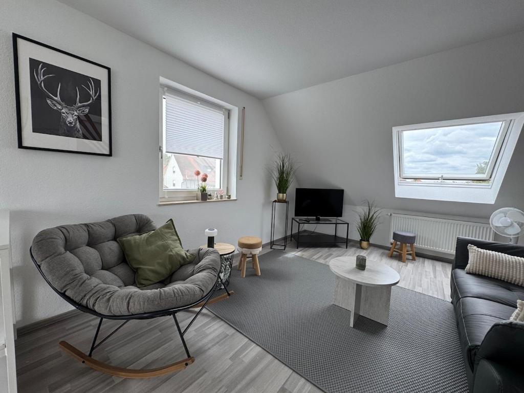a living room with a couch and a chair at Gemütliche Maisonette nahe Dinkelsbühl in Schopfloch
