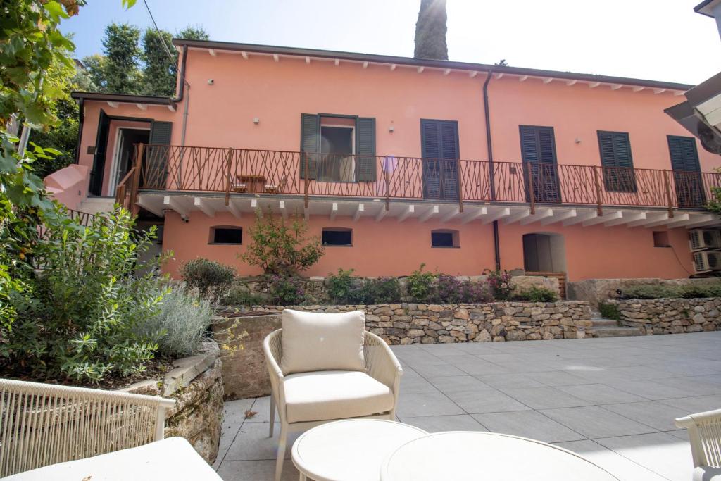 a patio in front of a pink house at OASI Apartment in Le Grazie