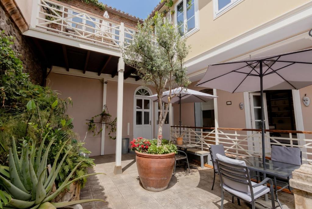a patio with a table and an umbrella at Orotava The Home - Vacational rental with the lifestyle of 1700 and the comfort of 2022 in La Orotava