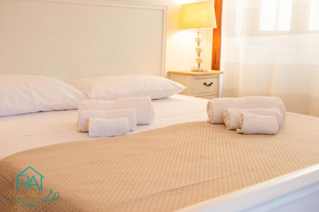 a bed with white towels on top of it at Roan Home Pompei 2 in Pompei