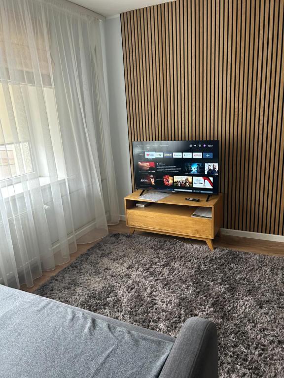 a living room with a flat screen tv on a stand at ModernNest in Ventspils