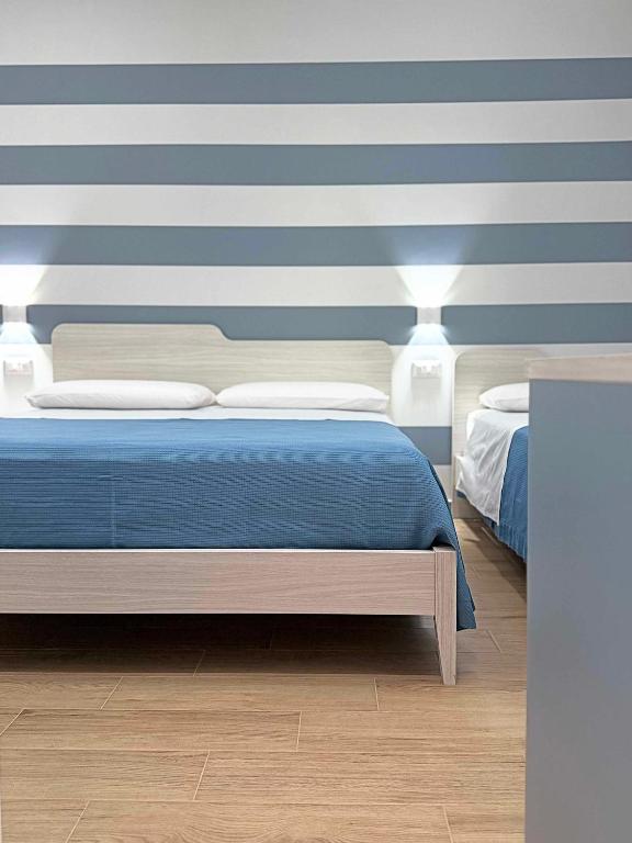 a bedroom with a blue and white striped wall at Tra 2 Blu Guest House in Belvedere Marittimo
