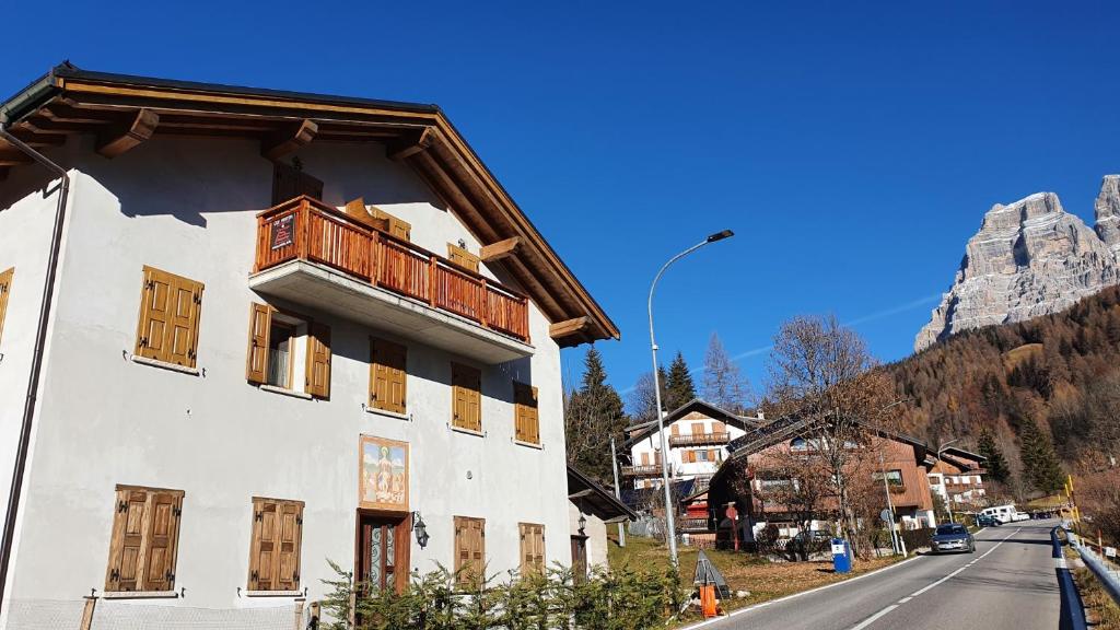 a building with a balcony on the side of a street at Casa Monego in Fusine