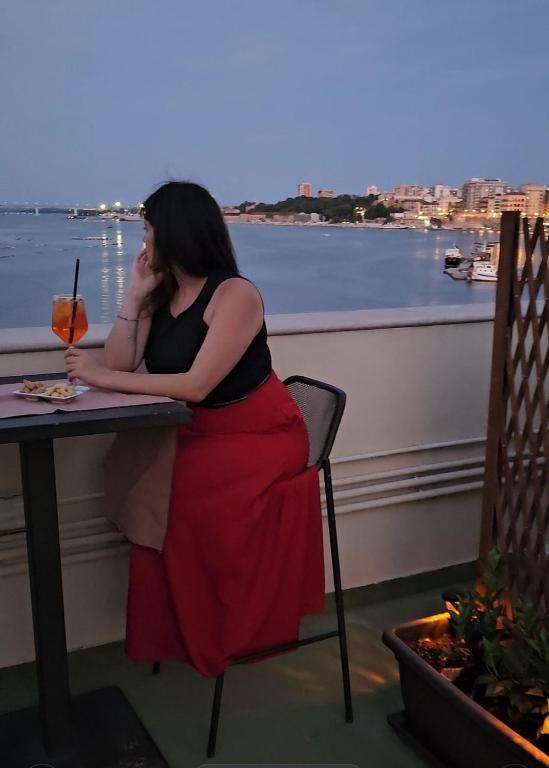a woman sitting at a table talking on a cell phone at Albergo Del Sole in Taranto