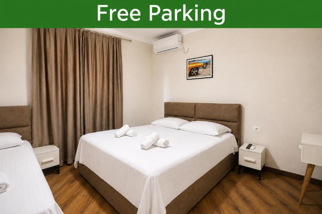 a hotel room with two beds and a free parking sign at Villa Reve de Tirana in Tirana