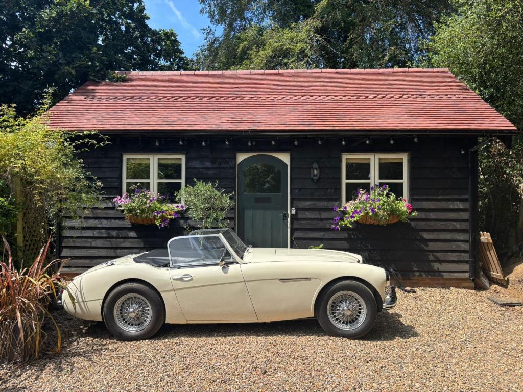 a white car parked in front of a small house at Park Cottage cabin in Bix