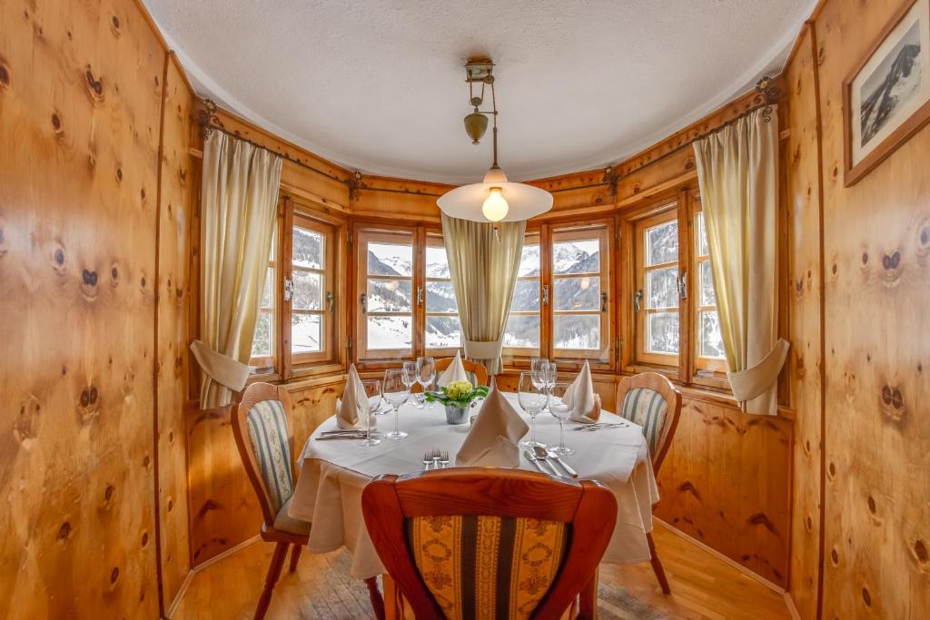 a dining room with a table and chairs and wooden walls at Hotel Berger Superior in Riva di Tures