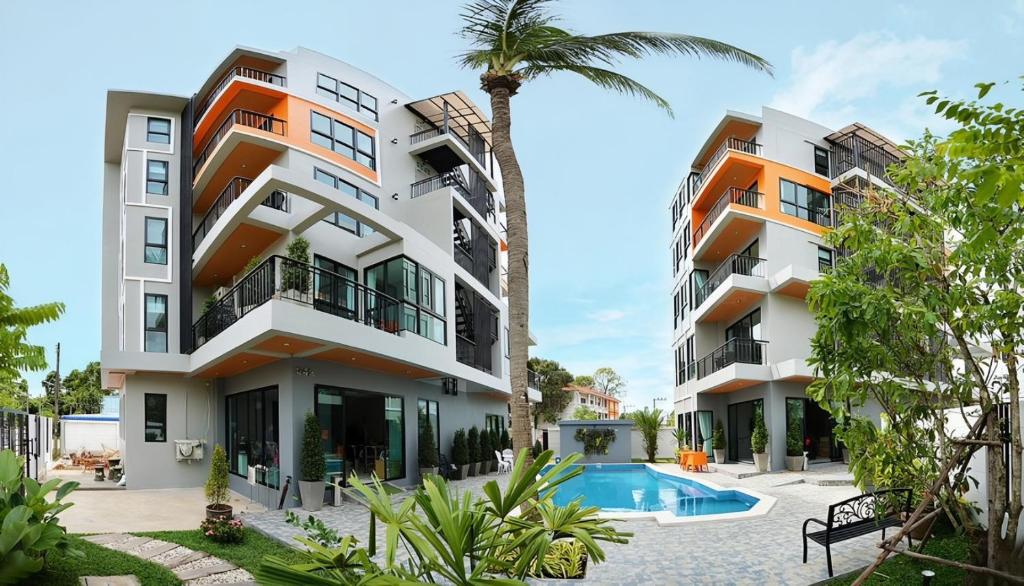 an apartment building with a swimming pool and a palm tree at The Lucky Beach Ao Nang in Ao Nang Beach