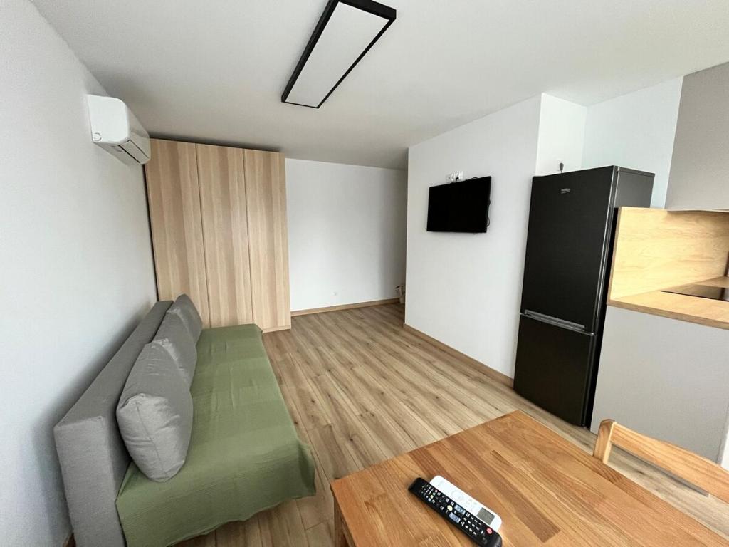 a living room with a couch and a refrigerator at Apartament przy plaży in Zbąszyń
