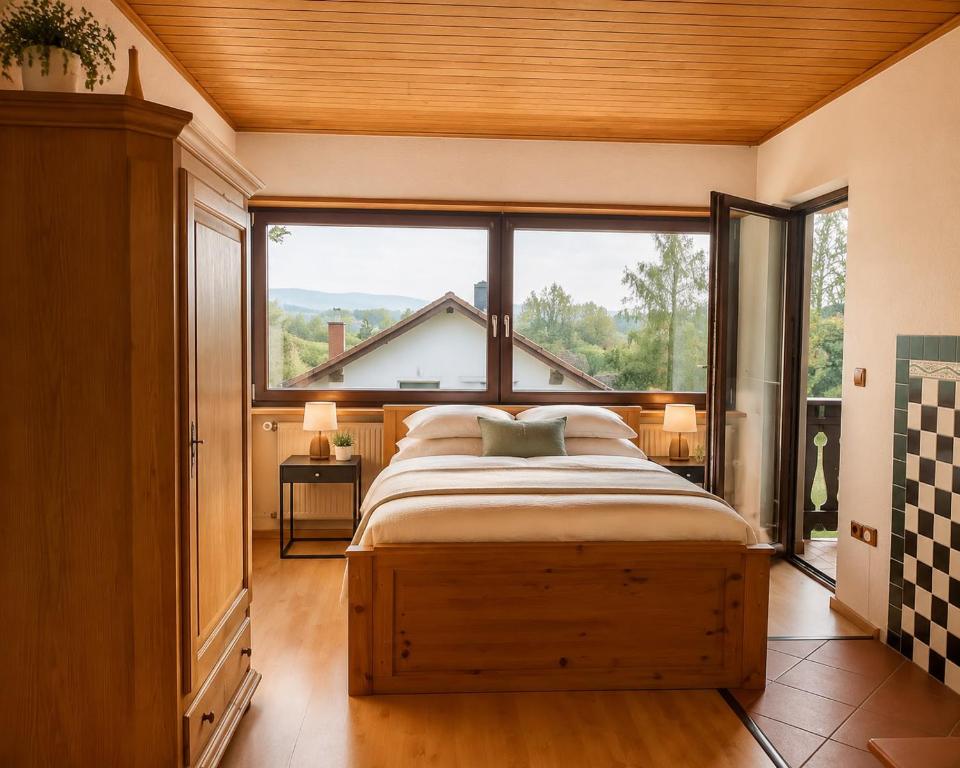 a bedroom with a bed and a large window at Odw homes - naturnahe Wohnung im Landhaus in Trösel