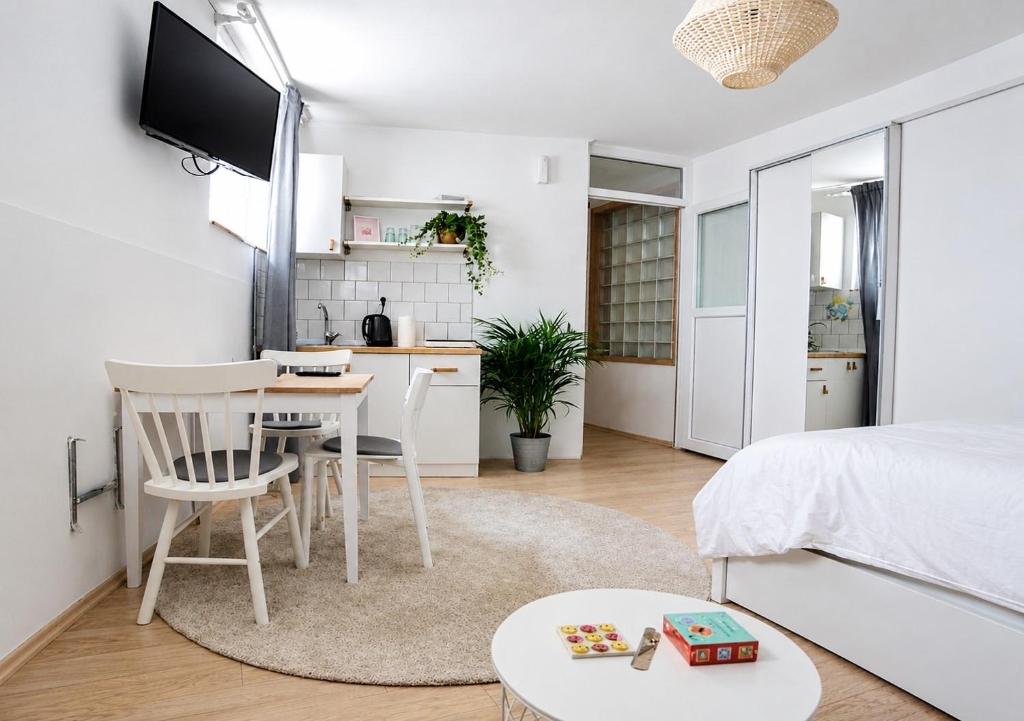 a bedroom with a bed and a table and a kitchen at Studio Apartments Siesta in Sarajevo