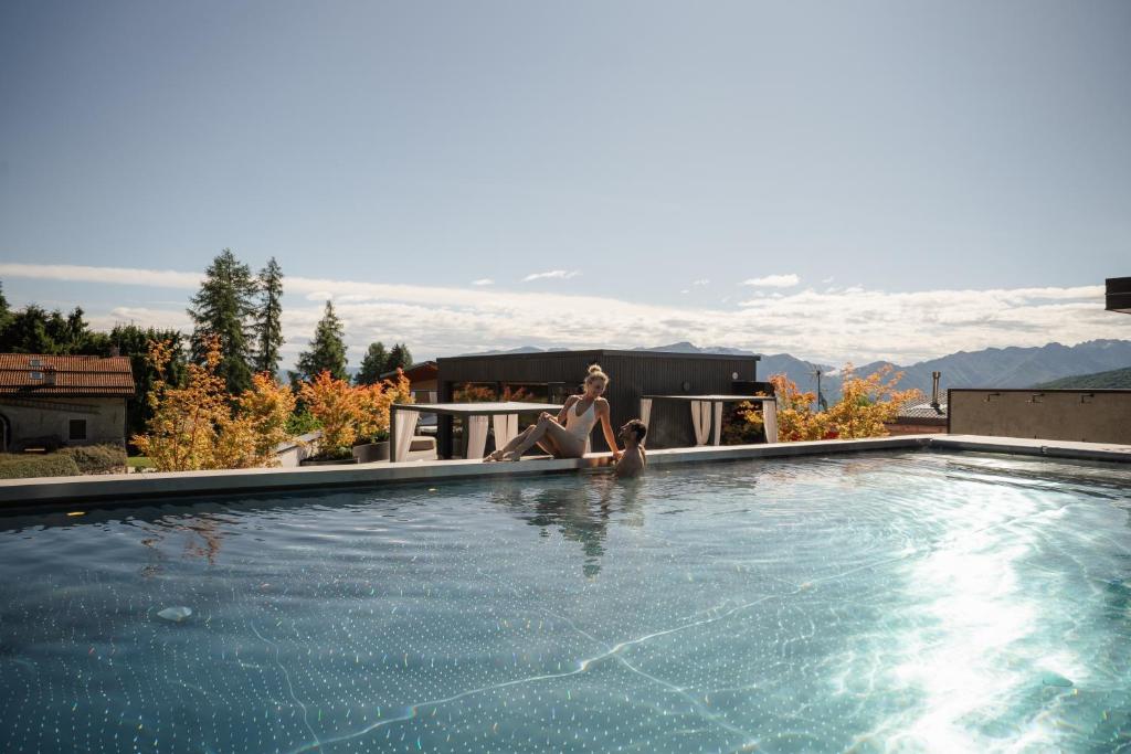 two women sitting in a swimming pool at ELGUS Nature Retreat in Brentonico