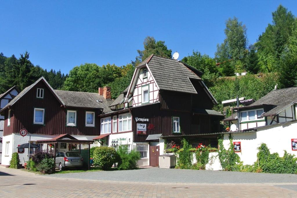 ein großes schwarzweißes Gebäude in einem Dorf in der Unterkunft Ferienwohnungen Treseburg "Zur Bodehexe" in Thale